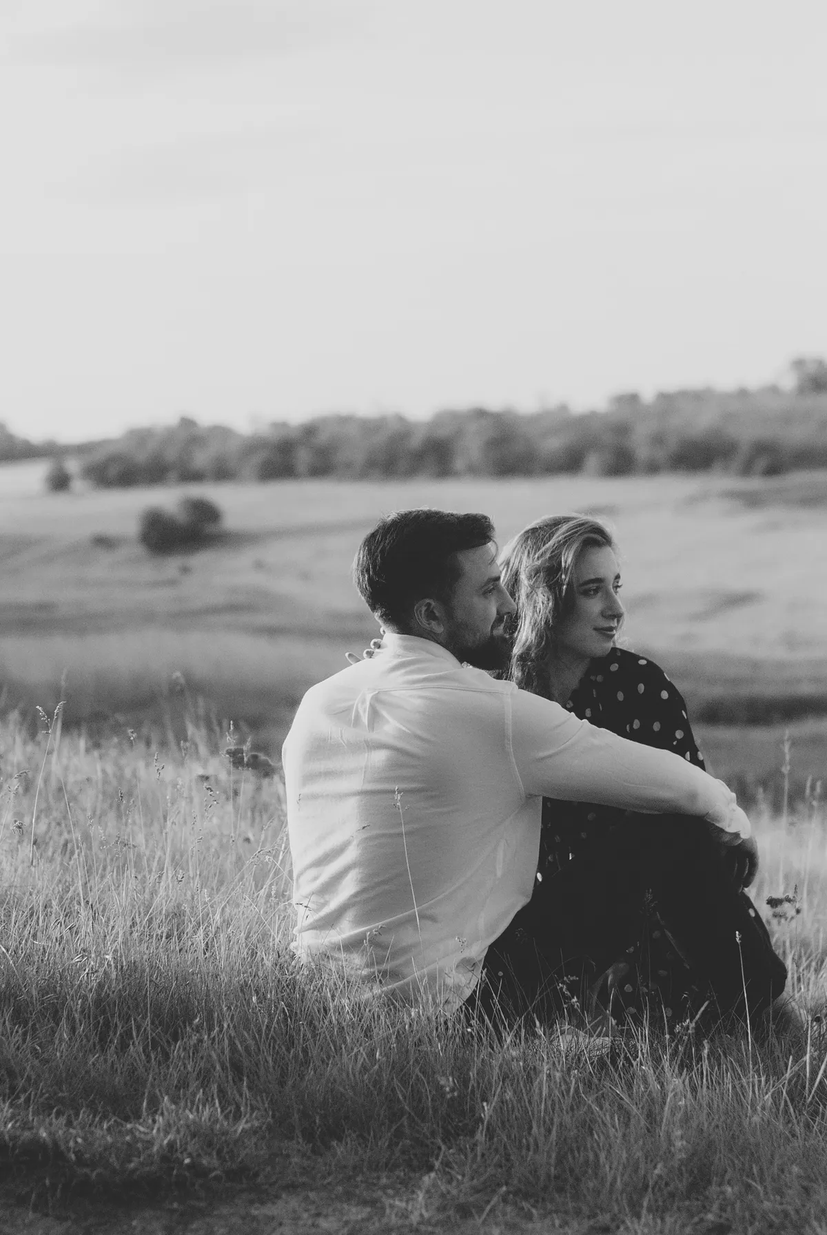 Delphine und Samuel sitzen eng beieinander im Gras, schwarzweiß