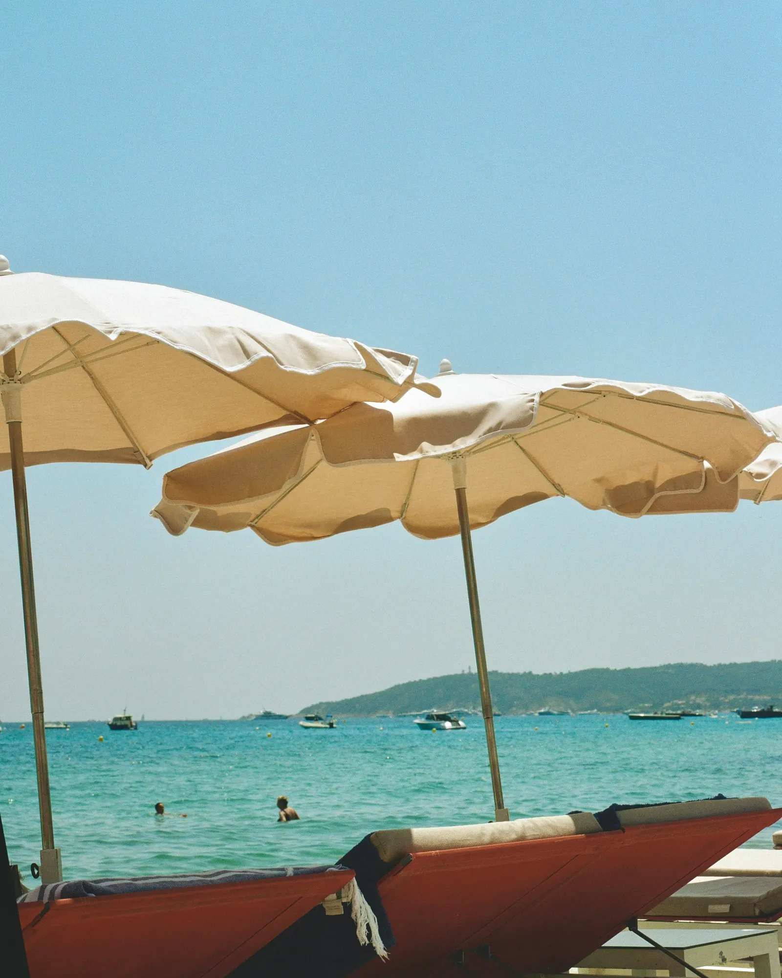 Sonnenschirme am azurblauen Strand von Nizza